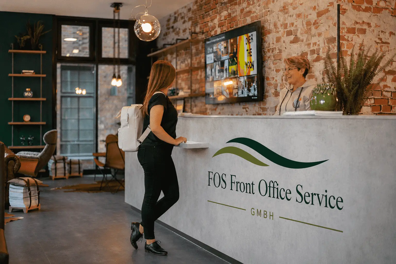 Check In Situation vor grauem Tresen mit FOS Logo